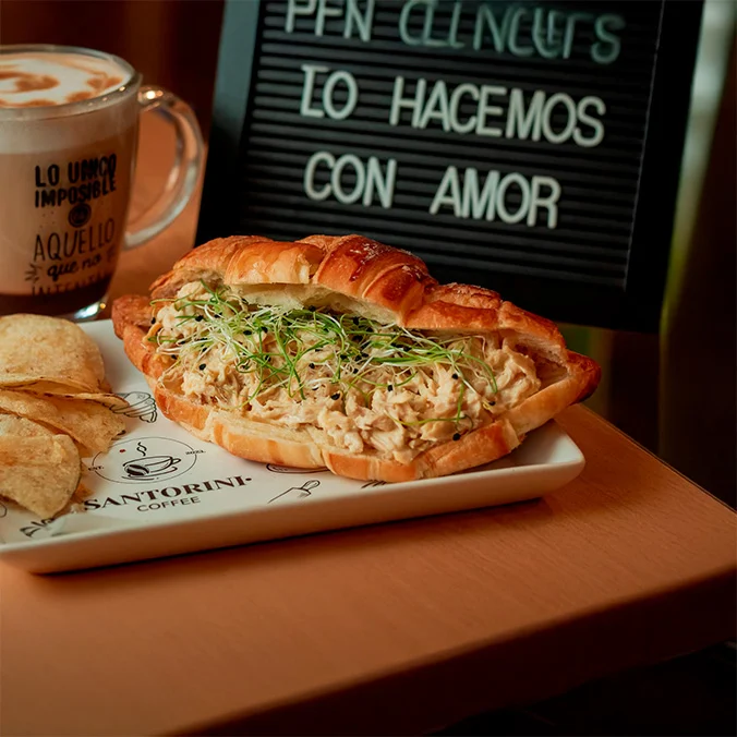 Croissant de pollo acompañado de café